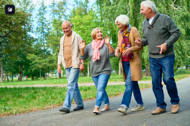 dos parejas de personas adultas disfrutando una caminata en un parque, ellos rien.