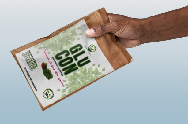 La mano de una persona de color sosteniendo un sobre de Glucon polvo. con fondo azul